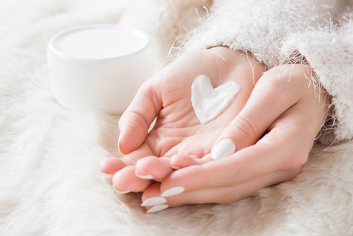 Beautiful Groomed Woman's Hands With Cream Jar On The Fluffy Blanket
